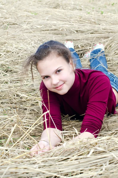Chica se acuesta en una hierba seca —  Fotos de Stock