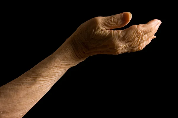 Les mains de la vieille femme sur un fond noir — Photo