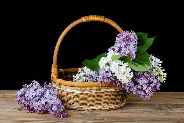 Lilac bouquet in a wattled basket — Stock Photo, Image