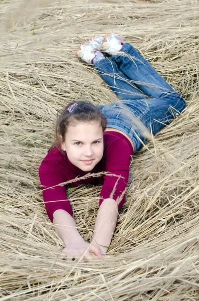 Girl lays on a dry grass — Stock Photo, Image