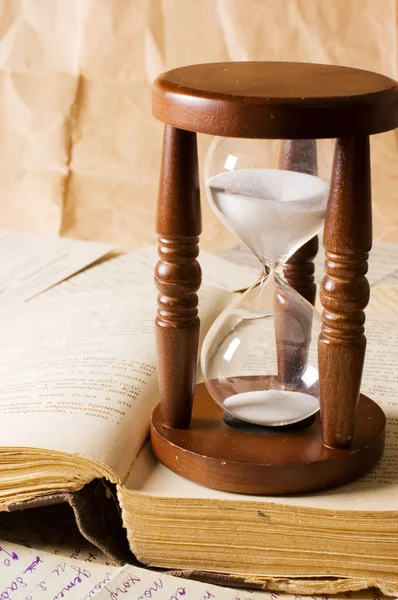 Песочные часы и книга — стоковое фото