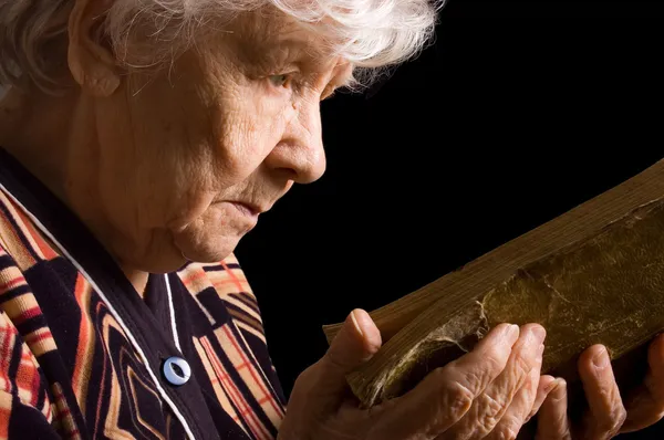 De oudere vrouw leest het boek — Stockfoto
