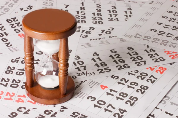 Hourglass on calendar sheets — Stock Photo, Image