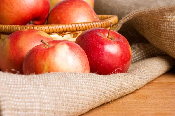 Яблука на мішку на дерев'яному столі — стокове фото