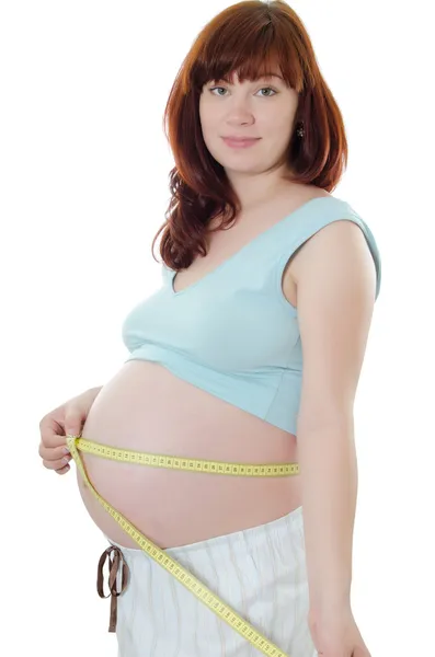 Femme enceinte avec un ruban à mesurer — Photo