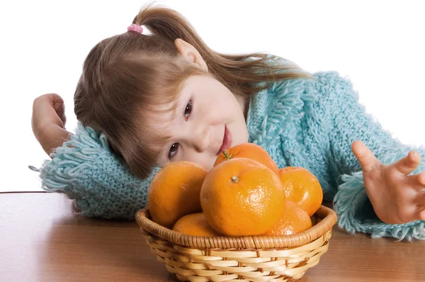 Het kleine meisje met mandarijnen — Stockfoto