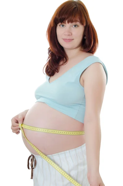 Pregnant woman with a measuring tape Royalty Free Stock Photos
