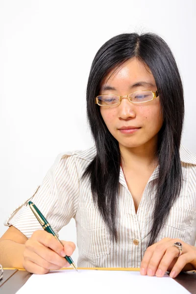 stock image Chinese businesswoman, sitting at desk writing