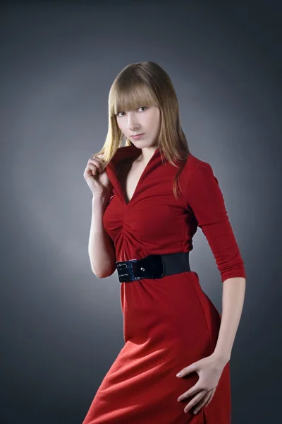 Krásná blondýna nosí červené šaty pózuje — Stock fotografie