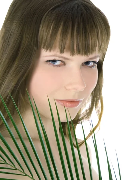 Joli visage de femme cachée derrière la grande feuille de palmier verte — Photo