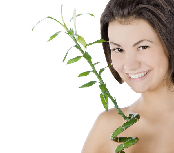 Beautiful young woman with a bamboo plant over white