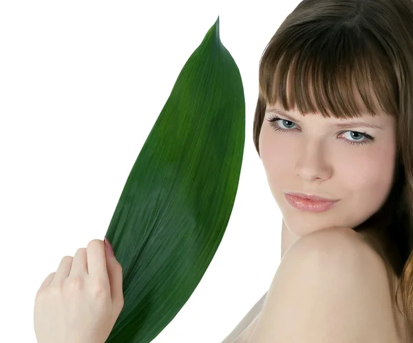 Joli visage de femme cachée derrière la grande feuille de palmier verte — Photo