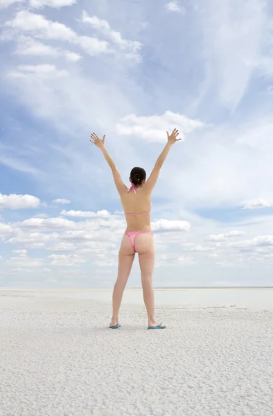 Молодая женщина стоит на пляже и наслаждается солнцем — стоковое фото