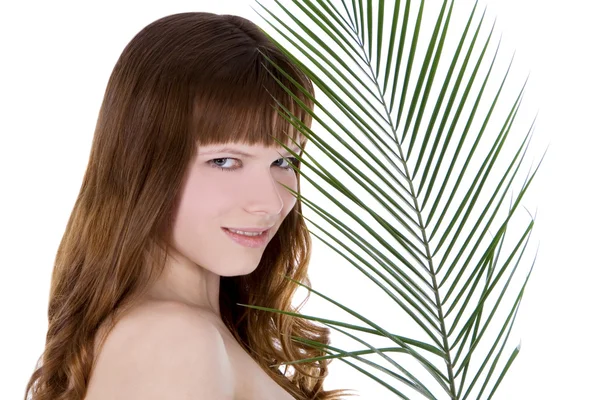Pretty face of woman hiding behind the big green palm leaf — Stock Photo, Image