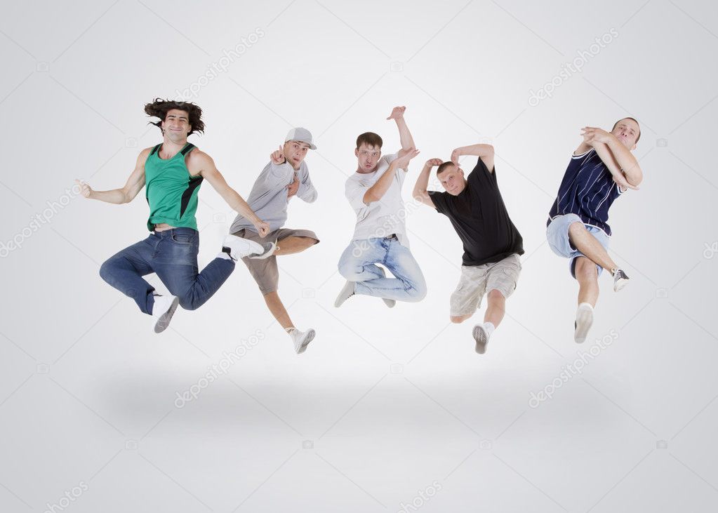 Group of young teenagers jumping over white