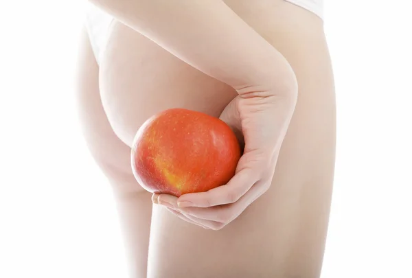 Mulher magro segura uma maçã posando contra fundo branco . — Fotografia de Stock