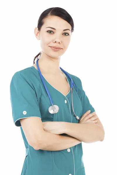 Médico femenino con estetoscopio posando contra espalda blanca —  Fotos de Stock