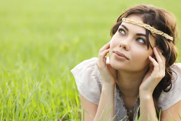 Junge brünette Frau liegt im Gras und schaut nach oben — Stockfoto