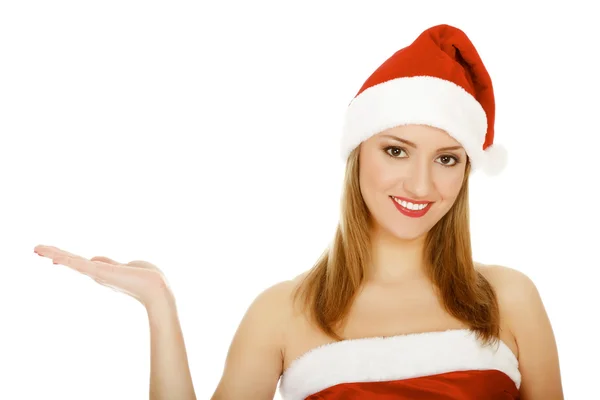 Menina bonita vestindo chapéu de Natal vermelho, segurando palma da mão para cima — Fotografia de Stock