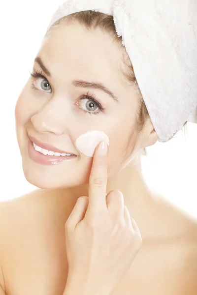 Mooie vrouw toepassing moisturizer crème op gezicht. — Stockfoto