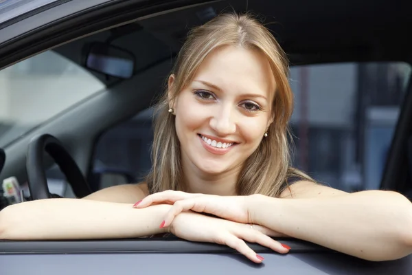 웃는 젊은 예쁜 여자는 차에 — 스톡 사진