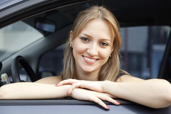 Sorridente giovane bella donna in macchina — Foto Stock