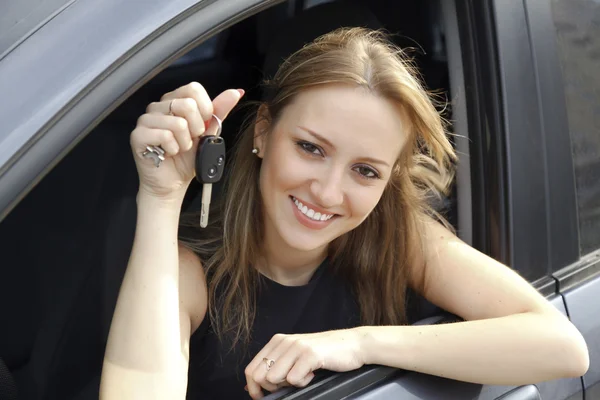 Šťastná žena ukazující klíč od svého nového auta — Stock fotografie