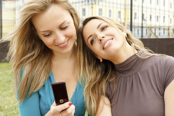 Young beautiful girls with mobile phone — Stock Photo, Image