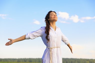 Young happy woman in green field, evening light clipart