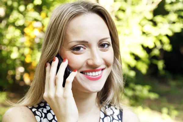 Außenporträt einer jungen Frau, die mit dem Handy spricht — Stockfoto