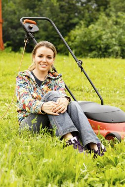 Young beautiful woman gardening and trimming the lawn clipart