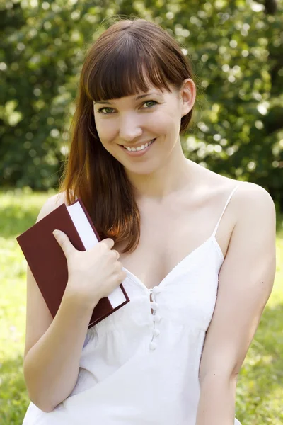 Portrait of a woman with a book outdoors — Stock Photo, Image