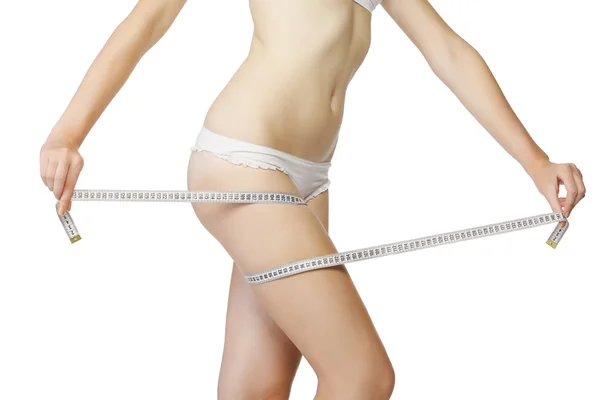 Mujer midiendo su muslo con una cinta métrica blanca —  Fotos de Stock