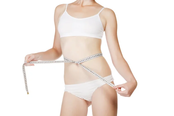 Mulher medindo o tamanho de sua cintura com uma fita métrica — Fotografia de Stock