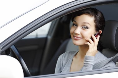 mutlu genç kadın arabada otururken cep telefonuyla konuşmak