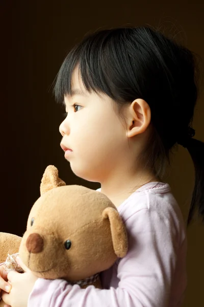 Criança sorridente com um urso de pelúcia — Fotografia de Stock