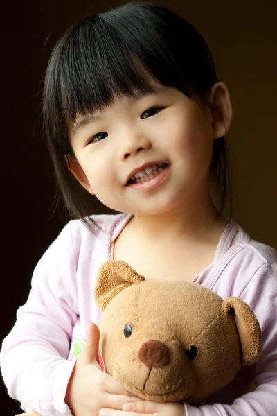 Küçük bir çocuk oyuncak ayı ile gülümseyen — Stok fotoğraf