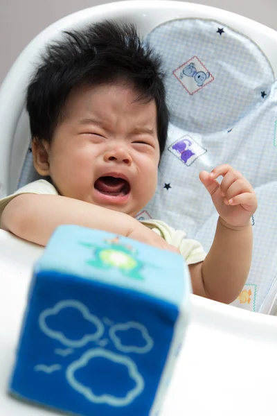 Pequena menina asiática chorando em uma cadeira alta — Fotografia de Stock