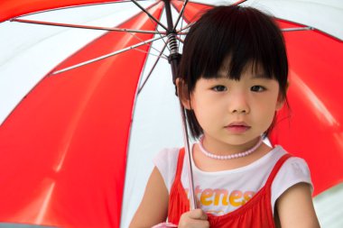 Asyalı çocuk kırmızı şemsiye ile