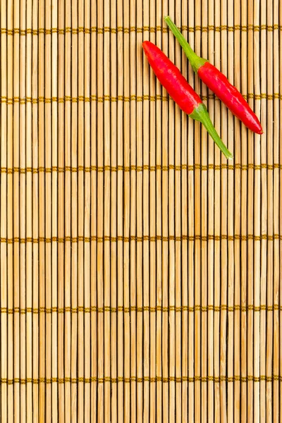 Červené chilli na bambusové rohoži — Stock fotografie