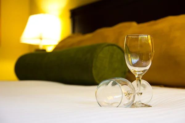 Dvě prázdné sklenice na posteli — Stock fotografie