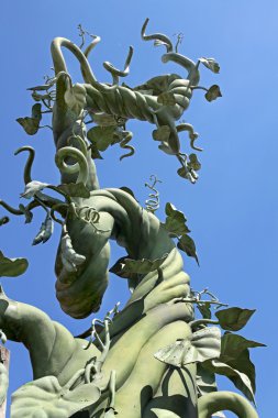 A beanstalk growing up into the blue sky clipart