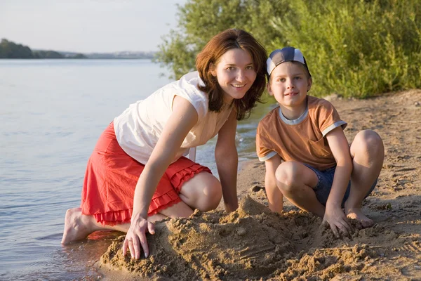 Matka i syn, grając na brzegu jeziora — Zdjęcie stockowe