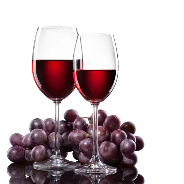 Vinho tinto em copos com uva isolada em branco — Fotografia de Stock