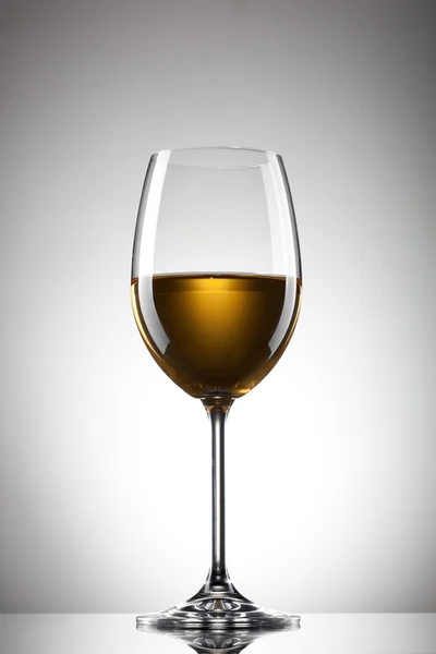 白葡萄酒在白纸上的玻璃 — 图库照片