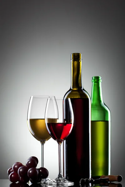 Vinho tinto e branco em copos com uva e garrafas — Fotografia de Stock