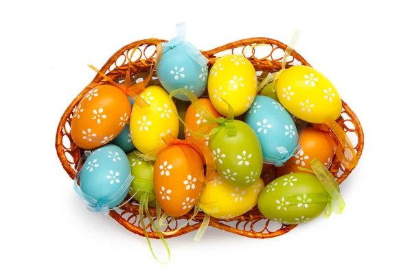 Ovos de páscoa a cores em cesta isolada em branco. vista superior — Fotografia de Stock