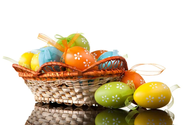 Ovos de páscoa a cores em cesta isolada em branco. vista superior — Fotografia de Stock