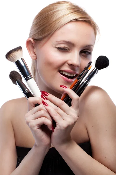 Jovem mulher sorridente com maquiagem escovas isoladas em branco — Fotografia de Stock
