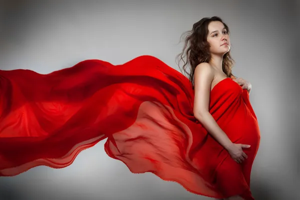 Έγκυος γυναίκα με κόκκινο φόρεμα — Φωτογραφία Αρχείου